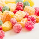 A vibrant display of assorted colorful hard candies on a white background.