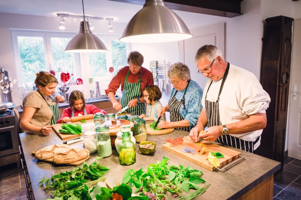 Grands parents et enfants coupants légumes bio